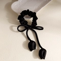 Elegant black satin scrunchie with a bow and delicate tulip pendants on beige texture - Black