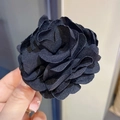 Elegant black fabric flower hair claw clip featuring realistic petal texture in hand - 240 Flower Hair Clip - Black