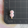 Gros plan de miniatures de sucettes roses et blanches de 1,5 cm sur un tapis gradué - Brochette de craquelins aux crevettes