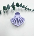 Elegant purple matte shell-shaped hair claw clip on a clean white background with leaves - Lavender