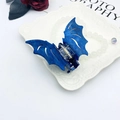 Detailed view of dark blue bat-shaped hair claw with glitter finish on white ceramic plate - Blue Purple Starry Sky