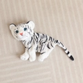 Top view of white tiger plush toy skin with black stripes and blue eyes on fabric - 23cm (No Filling/No Zipper) / White Tiger Shell