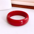 Close-up of a glossy wide red resin bangle with a polished reflective finish - Bright Red High Gloss Round Style