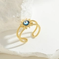 Makroaufnahme eines goldenen Kordelrings mit einem blauen Sonnenblumen-Auge-Motiv - Königsblauer Emaille-Stil (JZ0409)