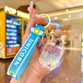 Close-up of blue unicorn liquid glitter bottle keychain with silicone wristband and bells - White Luminous Bubble Bead Gas Tank