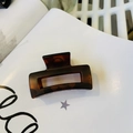 Detail view of the rectangular tortoiseshell resin hair claw clip in dark amber finish - Matte Red Brown