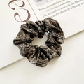 Glossy silk scrunchie with snakeskin pattern displayed on a magazine - Snake Skin Print