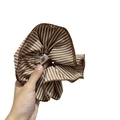 Dettaglio dell'elastico scrunchie in tessuto a righe marroni con trama e elastico - Marrone