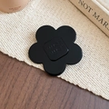 Detailed macro view of black resin flower grip featuring engraved wer wer text - Camellia Style / Black / Large
