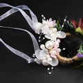 Detailed macro view of white pearl bridal headpiece with soft petals and organza ribbons - Iron Wire Bracelet / Pink