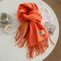 Orange and brown cashmere-like scarf with long tassels on a minimalist white table - 200cm / Orange