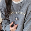 Chic silver oval metal pendant necklace on black leather cord, worn by model on grey sweater - Necklace-Silver-Black