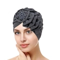 Detailed close-up of dark grey turban featuring a layered flower and pearl bead accents - Dark Gray