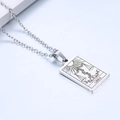 Macro detail of silver Libra tarot pendant featuring sun and plant engraving on stainless steel - Libra / Steel