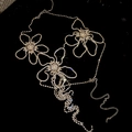 Detailaufnahme der glitzernden Strass-Blumen-Körperkette mit verstellbaren Gliedern auf Schwarz - Gold