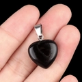 Pendentif coeur en obsidienne noire avec fermoir argenté tenu dans la main - Agate noire