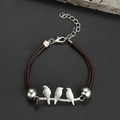 Detailed shot of handmade hummingbird bracelet with brown braided cord and silver bird accents - Three Birds on Branch Woven Bracelet-Brown Silver (12)