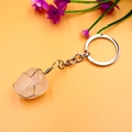 Macro view of wire-wrapped natural pink crystal pendant on a metal keychain - White Crystal