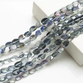Macro shot of 10x12mm twisted oval crystal beads with iridescent blue finish for DIY crafts - Semi-transparent Purple