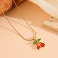 Dettaglio collana ciliegia dorata con cristalli rossi e verdi su elementi naturali - Collana Ciliegia Rossa / Oro