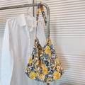 Gedetailleerd overzicht van geel-blauwe katoenen hobo-tas met bloemen aan een rek - Blauw Gele Bloemen Op Wit