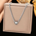 Silver bead necklace with chunky Cuban chain draped over a beige jewelry box - Single Steel Bead Necklace / Gold