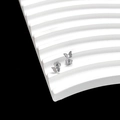 Macro shot of silver butterfly stud earrings on a geometric display stand with black background - Butterfly