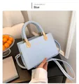 Détail du sac à main bleu clair à carreaux avec poignée tressée et boucle dorée - Bleu
