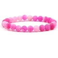 Macro shot of pink gradient beaded bracelet with cracked stone texture on white background - Pink