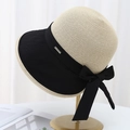 Close-up of beige straw hat with black brim, silk bow and metal 'LUCKY' tag detail - Black