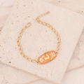 Detail of gold Sagittarius bracelet with orange enamel pendant and zircon inlays - Sagittarius