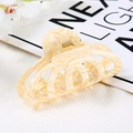 Detail of cream marble acetate hair claw clip with golden metal spring for elegant styling - Hollow Claw / Yellow