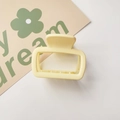 Detail of a square yellow plastic hair claw clip with internal teeth on a white card - Matte Small Square Yellow