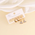 Macro shot of gold stainless steel geometric stud earrings set on white silk fabric - Triangle Zirconia Stud and Hoop Style (7#)