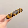 Close-up of smooth tortoise shell resin spring clip hair accessory with glossy finish - Dark Tortoiseshell