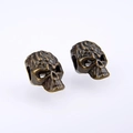 Detailed macro view of vintage bronze skull beads for DIY jewelry with side holes - Cyan Bronze