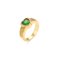 Macro detail of golden ring featuring green heart gemstone and vintage swirl engravings - Green