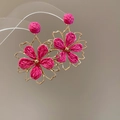 Detailed close-up of handmade gold-rimmed rose pink raffia flower drop earrings - Gold-Rose Red