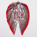 Detaillierte Makroansicht des roten Paisley-Musters auf glatter Satin-Seide Schal - Rot