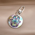 Bohemian Hamsa Hand and Evil Eye round keychain with silver metal clip on silk background - Colorful Small Hamsa Hand