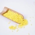 Bright yellow oval wax beans for hair removal displayed on a bamboo scoop - Bright Yellow Simulation Rice (500g)