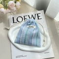 Detail view of the pleated blue and purple striped drawstring bag on a white tray - Bubble Blue Stripes