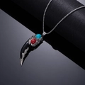 Macro view of wolf tooth pendant with silver metalwork and red turquoise stone inlay - Black Double-Sided Turquoise Carved Style with Red and Blue