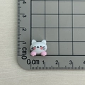 Detailed view of mini resin cat charm on a measuring ruler for DIY nail art and crafts - White Cat with Pink Paws