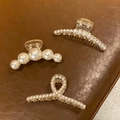 Three-piece set of elegant pearl hair clips with resin base on brown leather - Set 2