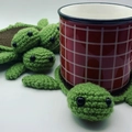 Handmade crochet turtle coaster in green and brown yarn with a checkered mug - Bronze & Dark Green