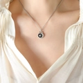 Silver star pendant necklace with black enamel disc and zirconia on model neck - 40+5cm / Silver