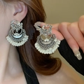 Detalle de los pendientes de fénix plateados con elegantes borlas de perlas en una modelo - 10# Pasador de Acero-Plata-Blanco