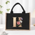 Black linen tote bag with gold letter H and floral print design on the front - Bronze Floral Letter H