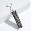 Detailed macro view of a rhinestone-studded cylindrical keychain with a metallic ring - 10ml / C7-Black & Yellow Camo